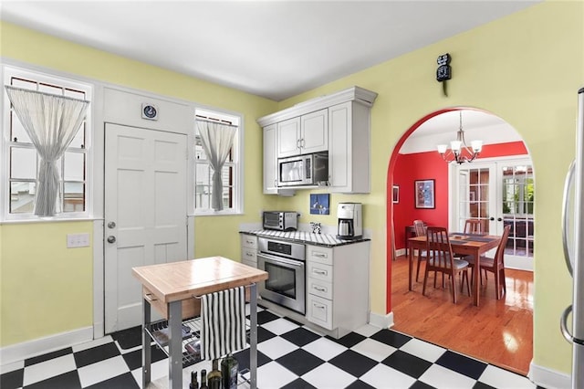 5800 Memphis St, New Orleans, LA 70124 - kitchen featuring stainless steel appliances, tile patterned floors, arched walkways, a chandelier, and baseboards