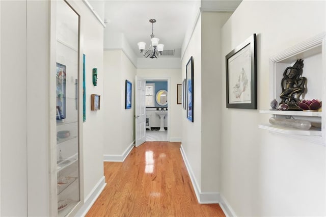 5800 Memphis St, New Orleans, LA 70124 - hall with a chandelier, light wood-type flooring, and baseboards
