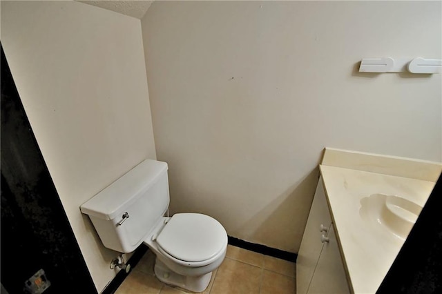 bathroom with tile patterned flooring, toilet, vanity, and baseboards