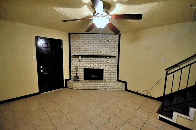 unfurnished living room featuring a textured ceiling, ceiling fan, light tile patterned floors, stairway, and a fireplace