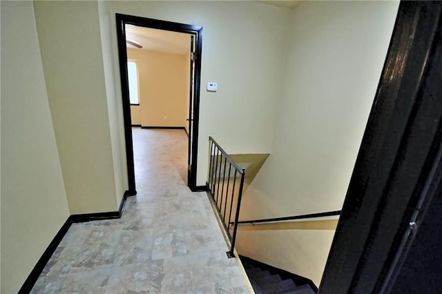 corridor with an upstairs landing and baseboards