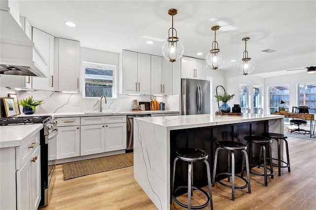 5116 Wilson Dr, Metairie, LA 70003 - kitchen featuring stainless steel appliances, custom exhaust hood, healthy amount of natural light, a sink, and recessed lighting