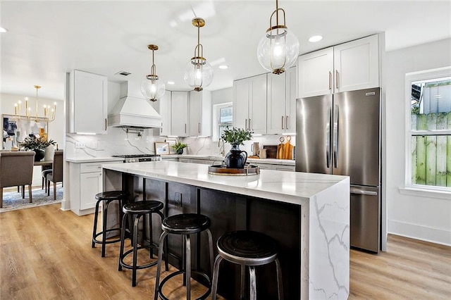 5116 Wilson Dr, Metairie, LA 70003 - kitchen featuring freestanding refrigerator, custom exhaust hood, a kitchen island, white cabinetry, and recessed lighting