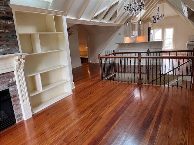 1113 Peniston St Unit A, New Orleans, LA 70115 - additional living space with a stone fireplace, a chandelier, hardwood / wood-style flooring, lofted ceiling, and built in shelves