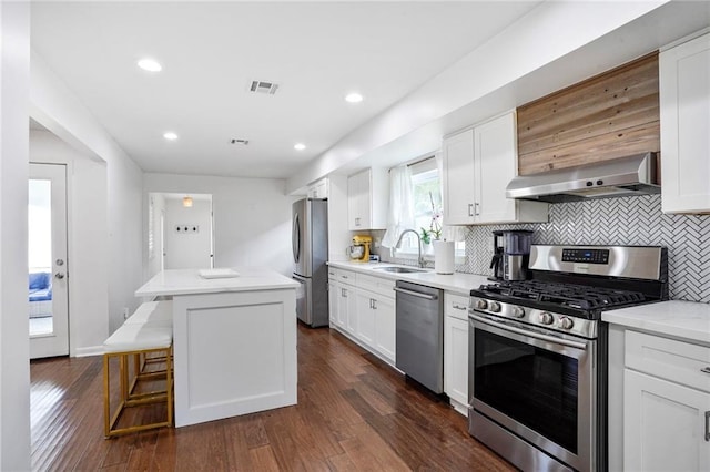 148 Macque Dr, Harahan, LA 70123 - kitchen featuring stainless steel appliances, wall chimney exhaust hood, a sink, a kitchen island, and backsplash