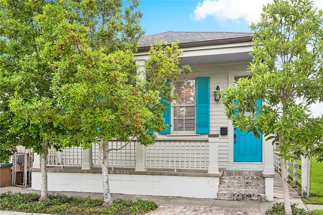 2025 First St, New Orleans, LA 70113 - doorway to property featuring fence and a shingled roof