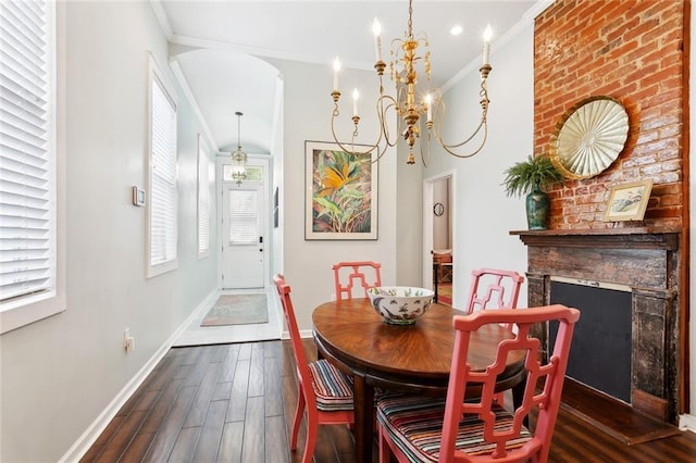 2025 First St, New Orleans, LA 70113 - dining area featuring crown molding, arched walkways, dark wood-type flooring, baseboards, and a large fireplace
