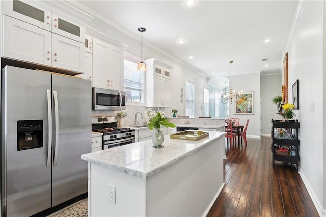 2025 First St, New Orleans, LA 70113 - kitchen with appliances with stainless steel finishes, a peninsula, baseboards, ornamental molding, and a center island