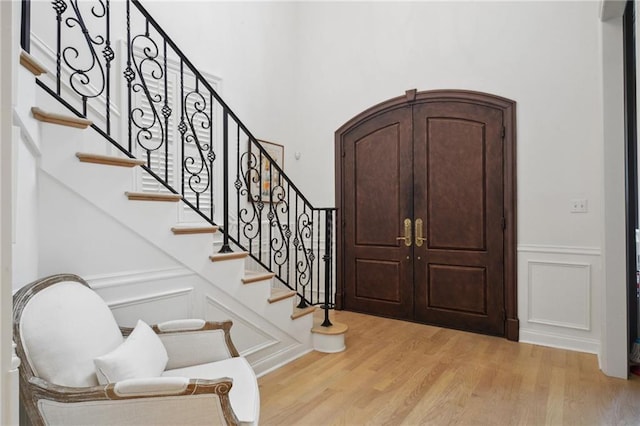3117 39th St, Metairie, LA 70001 - foyer featuring light wood-style flooring, a decorative wall, wainscoting, and stairs