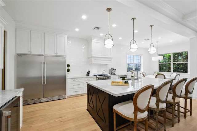 3117 39th St, Metairie, LA 70001 - kitchen featuring stainless steel built in fridge, beverage cooler, a breakfast bar, light wood-type flooring, and recessed lighting