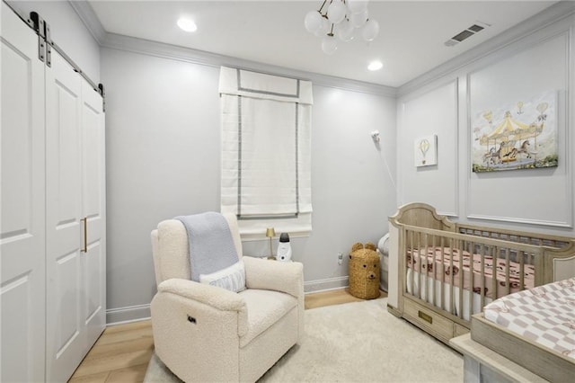 3117 39th St, Metairie, LA 70001 - bedroom featuring a barn door, a chandelier, crown molding, a nursery area, and recessed lighting