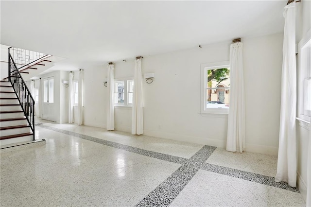 1729 Prytania St, New Orleans, LA 70130 - entrance foyer featuring plenty of natural light, speckled floor, stairs, and baseboards
