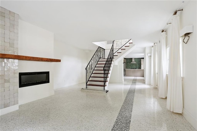 1729 Prytania St, New Orleans, LA 70130 - stairway with speckled floor, a glass covered fireplace, and baseboards