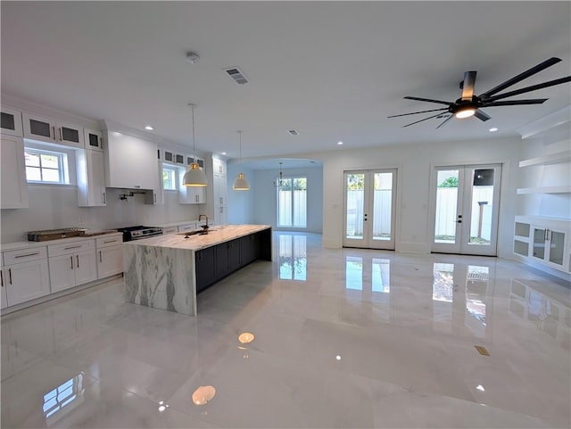 11 Cocos St, Kenner, LA 70065 - kitchen featuring french doors, an island with sink, white cabinetry, open floor plan, and recessed lighting