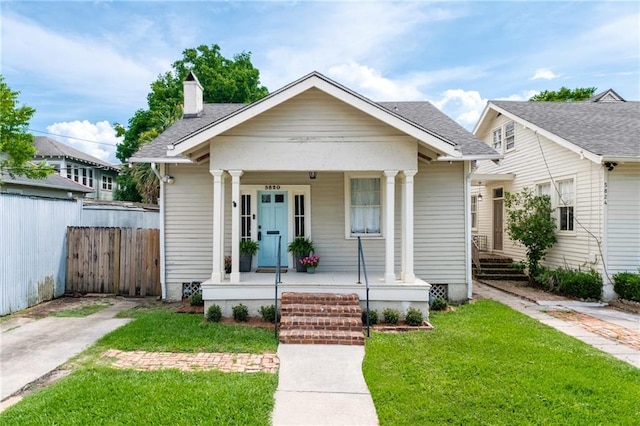 5820 Magnolia St, New Orleans, LA 70115 - bungalow with covered porch, a chimney, and roof with shingles