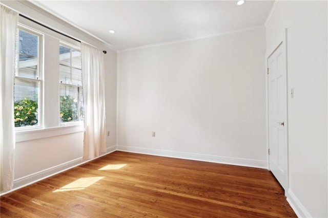 unfurnished room featuring wood finished floors, crown molding, baseboards, and recessed lighting