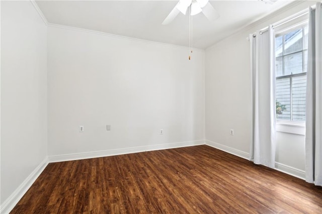 spare room with dark wood-type flooring, a ceiling fan, ornamental molding, and baseboards