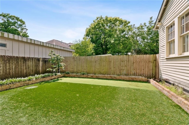fenced backyard featuring a putting area