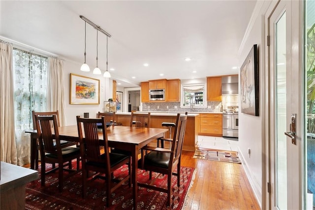 dining room with light wood-style floors, baseboards, and recessed lighting