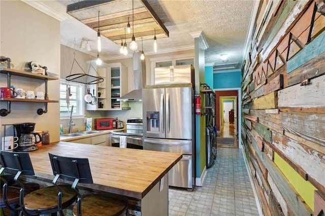 3115 Conti St, New Orleans, LA 70119 - kitchen featuring stainless steel appliances, a sink, butcher block countertops, open shelves, and wall chimney exhaust hood