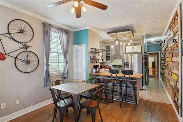 3115 Conti St, New Orleans, LA 70119 - dining space featuring wood finished floors, ornamental molding, ceiling fan, a textured ceiling, and baseboards