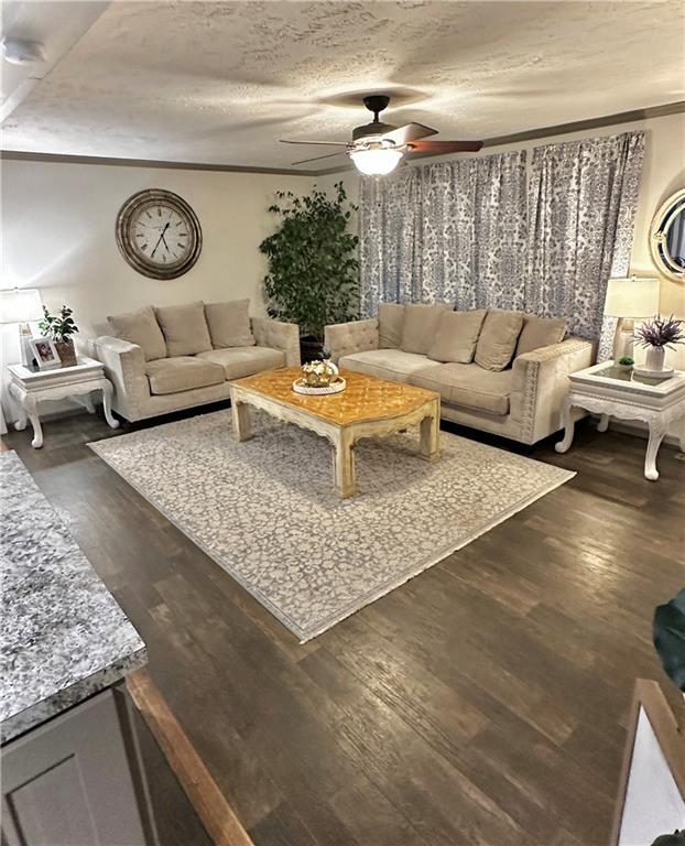 40140 Fire Tower Rd, Ponchatoula, LA 70454 - living area featuring ceiling fan, dark wood-style floors, ornamental molding, and a textured ceiling