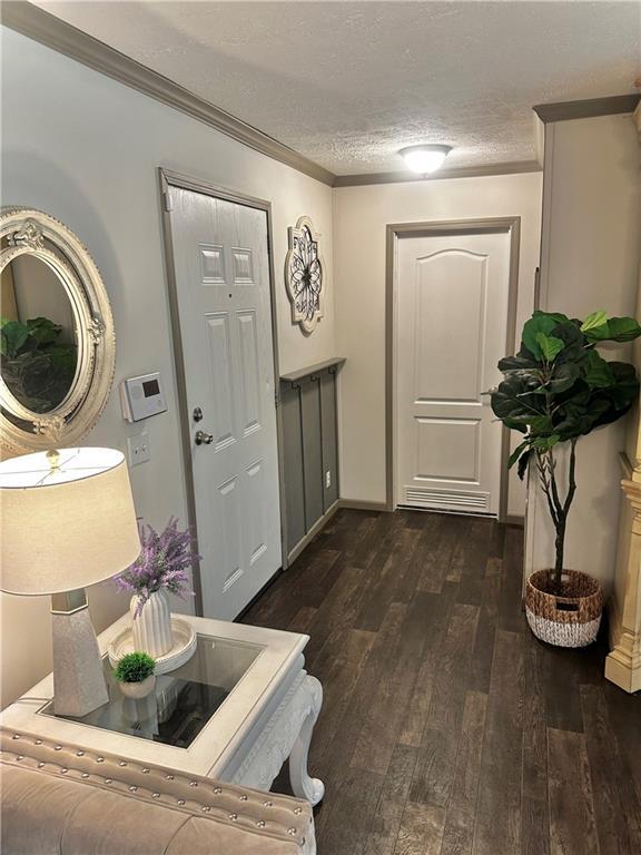 40140 Fire Tower Rd, Ponchatoula, LA 70454 - entrance foyer featuring dark wood finished floors, a textured ceiling, and crown molding