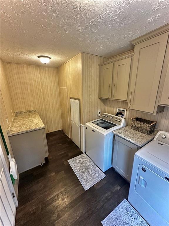 40140 Fire Tower Rd, Ponchatoula, LA 70454 - washroom with cabinet space, dark wood-style flooring, a textured ceiling, wood walls, and washing machine and dryer