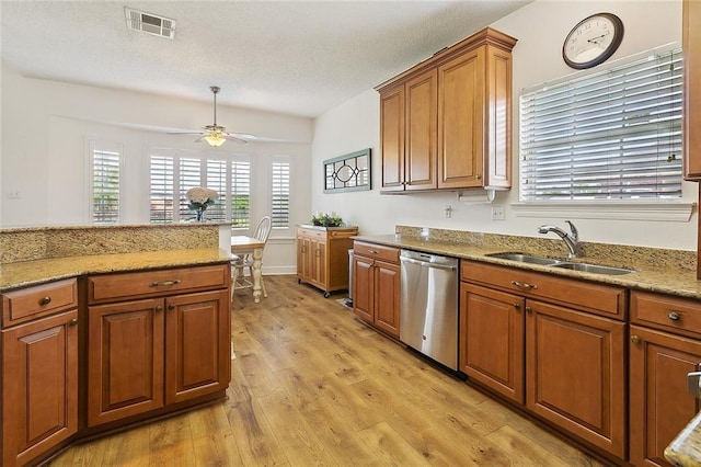 101 Portrush Dr, La Place, LA 70068 - kitchen featuring stainless steel dishwasher, a sink, brown cabinets, light wood finished floors, and ceiling fan