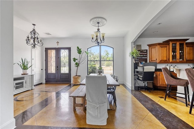 dining room with a chandelier and inlaid floor details