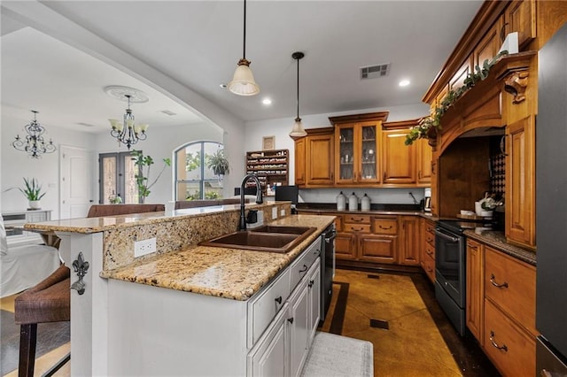 kitchen with a sink, range with electric cooktop, brown cabinets, a kitchen bar, and a kitchen island with sink