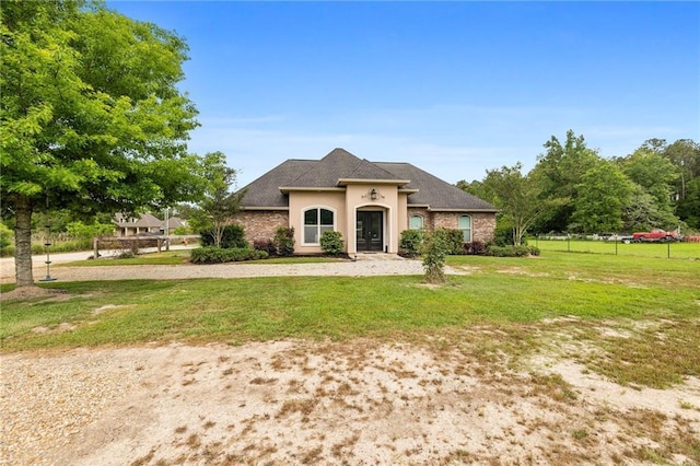 view of front of home featuring a front yard, stucco siding, and a shingled roof