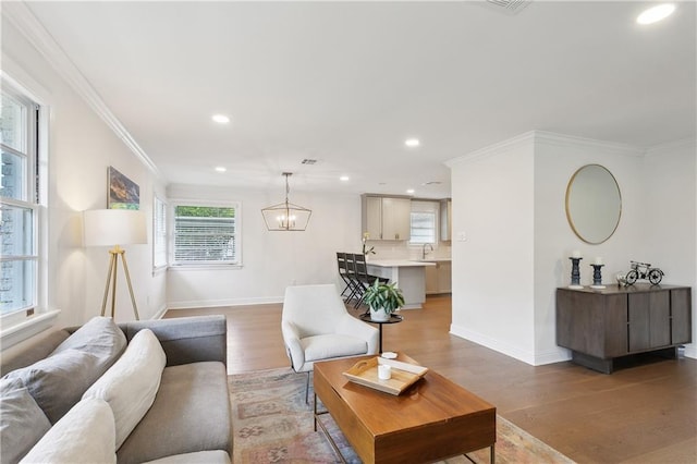 7449 Cameo St, New Orleans, LA 70124 - living area featuring crown molding, baseboards, light wood-style floors, recessed lighting, and a chandelier