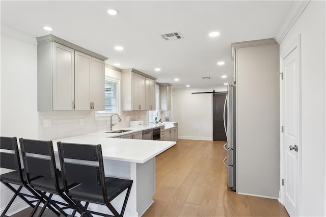 7449 Cameo St, New Orleans, LA 70124 - kitchen with a sink, stainless steel dishwasher, backsplash, a kitchen bar, and a peninsula