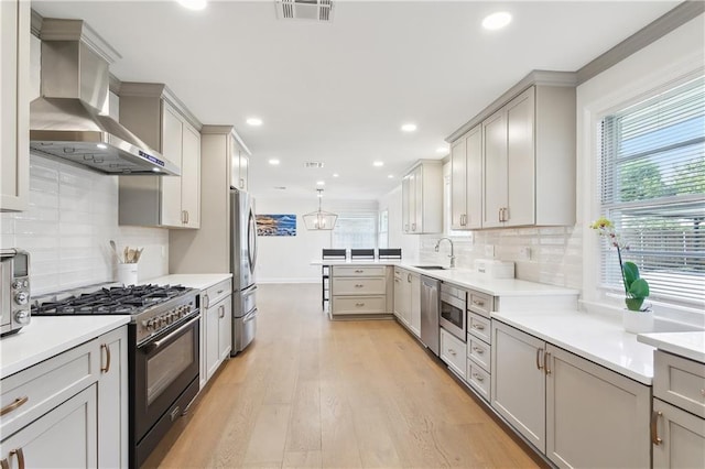 7449 Cameo St, New Orleans, LA 70124 - kitchen with appliances with stainless steel finishes, a sink, wall chimney range hood, healthy amount of natural light, and recessed lighting