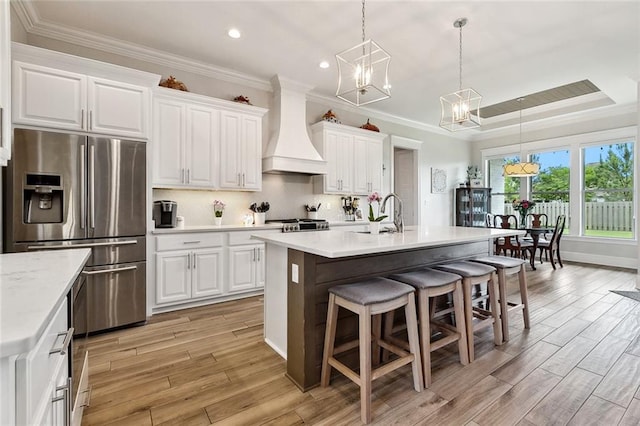 2040 Cypress Bend Ln, Madisonville, LA 70447 - kitchen featuring stainless steel fridge, custom range hood, a chandelier, a sink, and a breakfast bar area