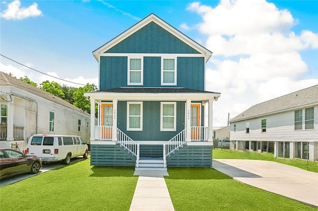 2830-32 Spain St, New Orleans, LA 70122 - american foursquare style home featuring a porch, a front lawn, and board and batten siding