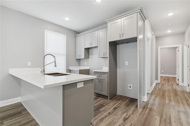 2830-32 Spain St, New Orleans, LA 70122 - kitchen featuring light wood-style flooring, gray cabinetry, a peninsula, light countertops, and recessed lighting