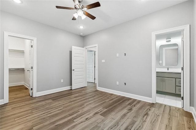 2830-32 Spain St, New Orleans, LA 70122 - unfurnished bedroom with light wood finished floors, a walk in closet, ensuite bath, a closet, and recessed lighting