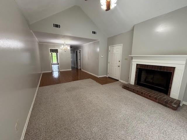 138 Woodland Ridge Dr, Mccomb, MS 39648 - unfurnished living room with carpet floors, a chandelier, ceiling fan, a brick fireplace, and high vaulted ceiling