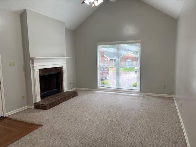 138 Woodland Ridge Dr, Mccomb, MS 39648 - unfurnished living room featuring ceiling fan, carpet flooring, lofted ceiling, a brick fireplace, and baseboards