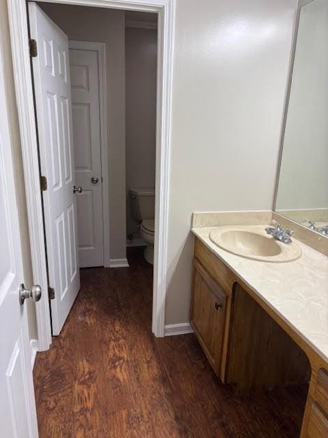 138 Woodland Ridge Dr, Mccomb, MS 39648 - bathroom featuring toilet, wood finished floors, vanity, and baseboards