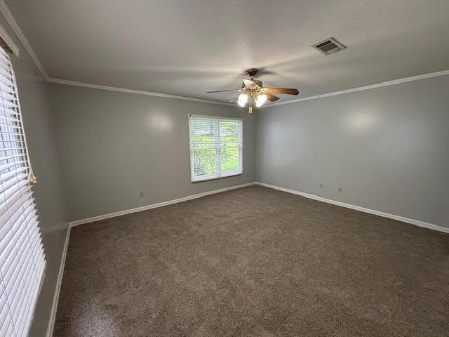 138 Woodland Ridge Dr, Mccomb, MS 39648 - spare room featuring ceiling fan, baseboards, crown molding, and dark colored carpet