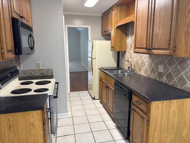 138 Woodland Ridge Dr, Mccomb, MS 39648 - kitchen featuring black appliances, light tile patterned floors, a sink, backsplash, and brown cabinets