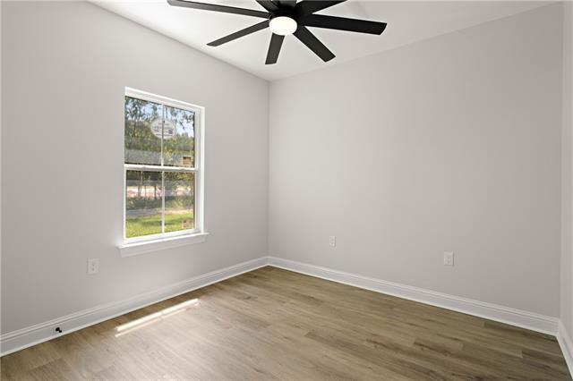 14321 Lake Tahoe Dr, Covington, LA 70433 - unfurnished room with a ceiling fan, wood finished floors, and baseboards