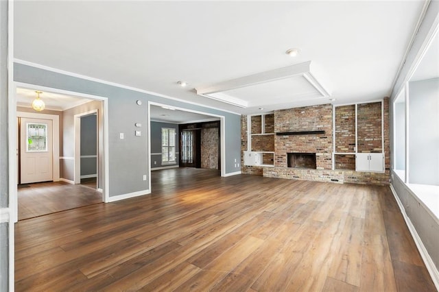 3501 Pin Oak Ave, New Orleans, LA 70131 - unfurnished living room featuring wood finished floors, baseboards, built in shelves, crown molding, and a brick fireplace