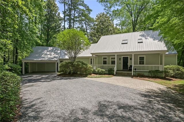1357 Park Dr, Mandeville, LA 70471 - view of front of house with gravel driveway, a porch, and metal roof