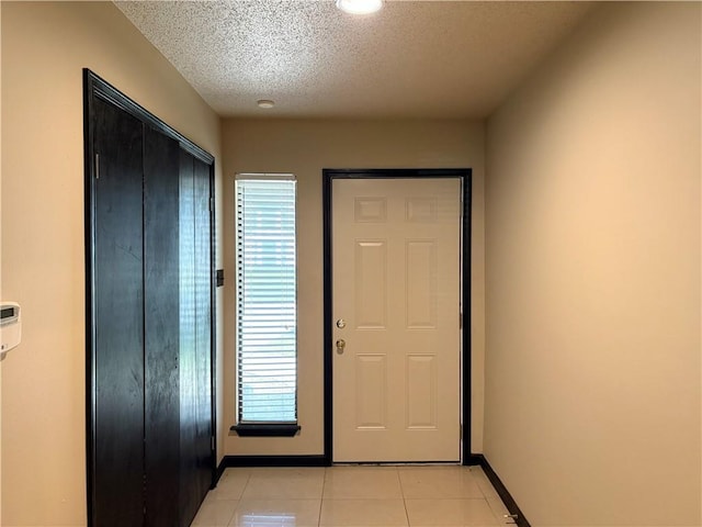 11240 Winrock Dr, New Orleans, LA 70128 - foyer entrance featuring baseboards, light tile patterned flooring, and a textured ceiling