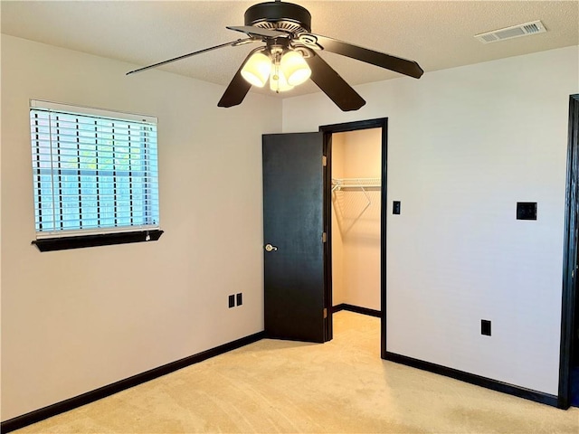 11240 Winrock Dr, New Orleans, LA 70128 - unfurnished bedroom featuring light carpet, a walk in closet, baseboards, a closet, and a ceiling fan