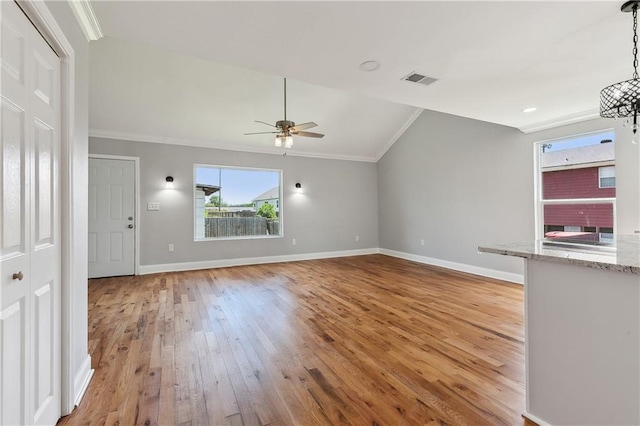 unfurnished living room featuring vaulted ceiling, light wood-style floors, a ceiling fan, crown molding, and baseboards